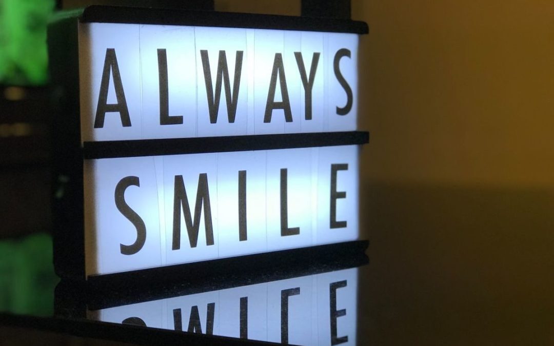 Things to Know About Invisalign x Illuminated sign displaying "Always Smile While" motivational message for dental practice.