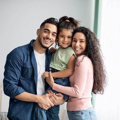 happy parents having fun time with their daughter after visiting dental office 